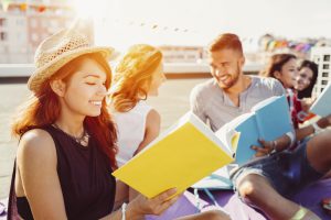 Friends with books on the rooftop having fun